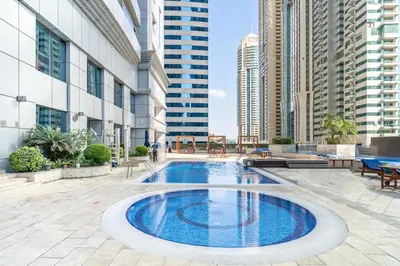 a swimming pool in the middle of a building with tall buildings at Veer Apartments - 82nd Floor Princess Tower - Palm View in Dubai