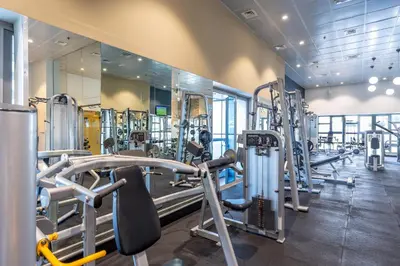 a gym with several tread machines and a mirror at Veer Apartments - 82nd Floor Princess Tower - Palm View in Dubai