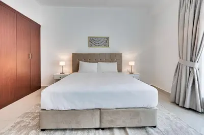 a bedroom with a large white bed and two lamps at 2 BD apartment in Bahar JBR in Dubai