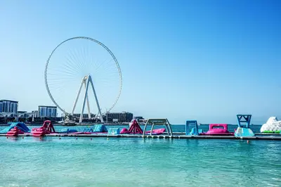 a large swimming pool with a ferris wheel in the background at 2 BD apartment in Bahar JBR in Dubai
