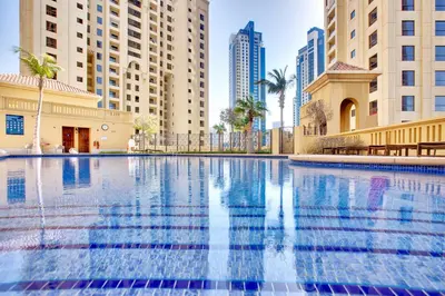 a swimming pool in a city with tall buildings at 2 BD apartment in Bahar JBR in Dubai