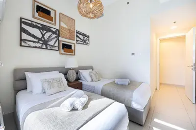 two beds in a room with white walls at Stylish 3 bedrooms Boho-Style Home in Dubai