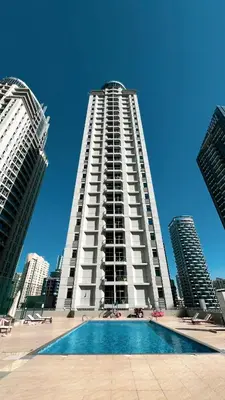 a tall building with a pool in front of it at Stylish 3 bedrooms Boho-Style Home in Dubai