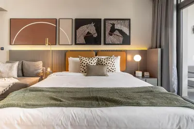 a bedroom with a large bed with four pictures on the wall at GuestReady - Charming Loft 7mins from Burj Khalifa in Dubai