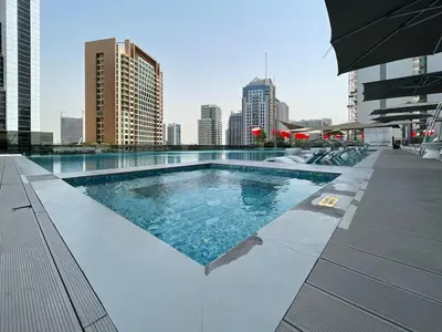 a swimming pool on top of a building with a city at GuestReady - Charming Loft 7mins from Burj Khalifa in Dubai