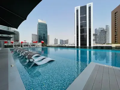 a swimming pool with a city skyline in the background at GuestReady - Charming Loft 7mins from Burj Khalifa in Dubai