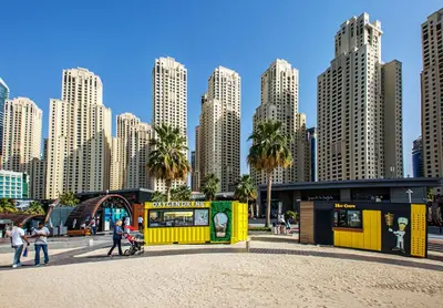 a yellow building in front of a city with tall buildings at 2BD apartment in Bahar JBR near beach in Dubai