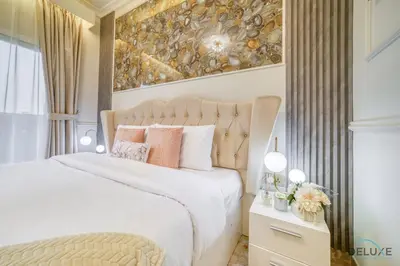 a bedroom with a white bed and a painting on the wall at Ornate 2BR at Diamond Views 1, Jumeirah Village Circle by Deluxe Holiday Homes in Dubai