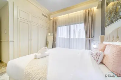 a bedroom with a large white bed with pink pillows at Ornate 2BR at Diamond Views 1, Jumeirah Village Circle by Deluxe Holiday Homes in Dubai