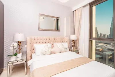 a bedroom with a white bed and a large window at Elite Royal Apartment - Panoramic Full Burj Khalifa, Fountain & Skyline View - ACed direct connection to Dubai Mall - Governor in Dubai