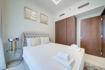 a bedroom with a white bed with two towels on it at Classic Arabian Elegance with City Views in Dubai
