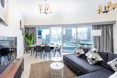 a living room with a couch and a table at 180° Sheik Zayed Road balcony views 2BR in JLT in Dubai