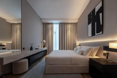a bedroom with a white bed and a bathroom at Lusso Hometels J One Business Bay in Dubai