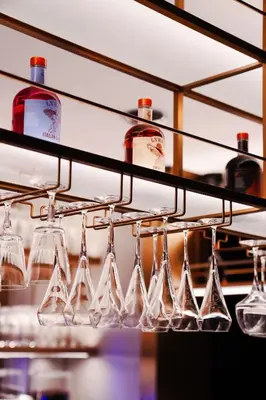 a row of wine glasses and bottles on a shelf at Lusso Hometels J One Business Bay in Dubai