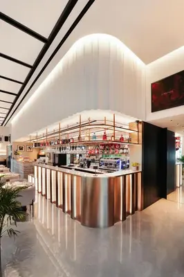 a restaurant with a bar in the middle of a building at Lusso Hometels J One Business Bay in Dubai