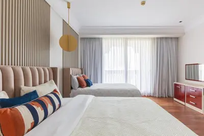 a hotel room with two beds and a television at 1-bedroom apartment with pool in Dubai