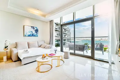 a living room with a couch and a table at LUX - The Elegant Palm Beach Suite in Dubai