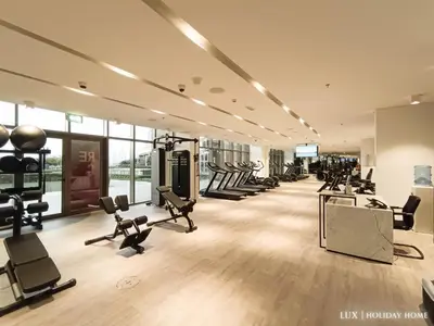 a gym with treadmills and cardio equipment in a room at LUX - The Elegant Palm Beach Suite in Dubai