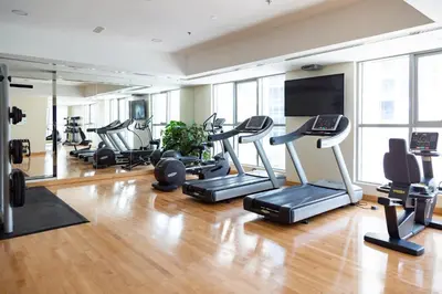 a gym with several treadmills and a flat screen tv at Frank Porter - The Point in Dubai