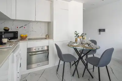 a white kitchen with a table and chairs at Frank Porter - The Point in Dubai