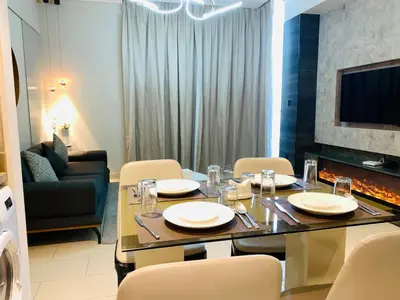 a dining room with a table and chairs and a couch at STAY BY LATINEM Luxury 2BR Holiday Home CV B2513 near Burj Khalifa in Dubai