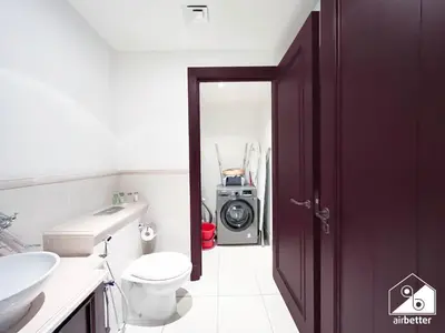 a bathroom with a toilet a sink and a washing machine at Luxury 2Bedroom in Dubai Old Town with Burj View in Dubai
