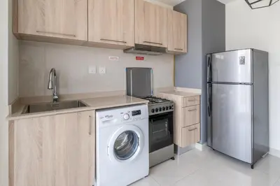 a kitchen with a refrigerator and a washing machine at GuestReady - Stylish Apt in Business Bay in Dubai