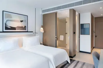a hotel room with two beds and a chair at Vida Dubai Marina & Yacht Club in Dubai