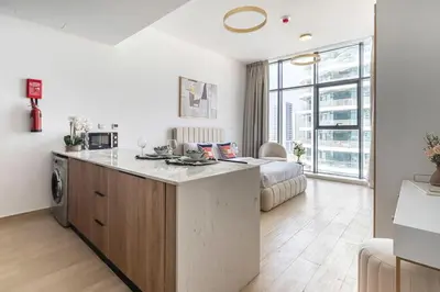 a kitchen with a large island in a room with a bed at Frank Porter - Regina Tower in Dubai