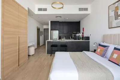 a bedroom with a large bed and a kitchen at Frank Porter - Regina Tower in Dubai