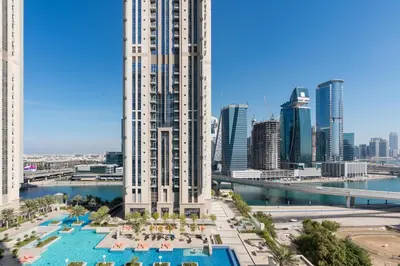 a view of a building with a pool and a city at White Sage - Amna Tower in Dubai