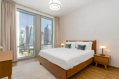 a bedroom with a large bed and a large window at White Sage - Amna Tower in Dubai