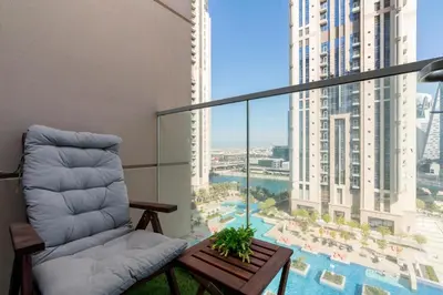 a living room with a couch and a large window at White Sage - Amna Tower in Dubai