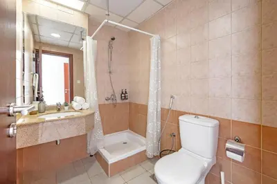 a bathroom with a toilet and a shower and a sink at Spacious 3BR with 180˚ Dubai Marina Views in Dubai
