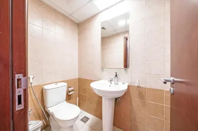 a bathroom with a toilet and a sink at Spacious 3BR with 180˚ Dubai Marina Views in Dubai