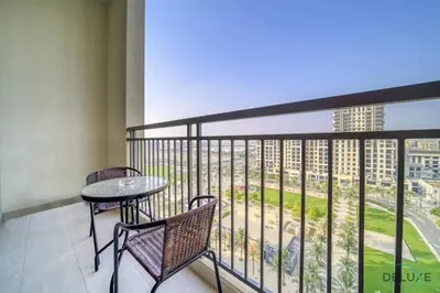 a balcony with a table and chairs and a view of a city at Sophisticated 1BR at Town Square Rawda Dubailand by Deluxe Holiday Homes in Dubai