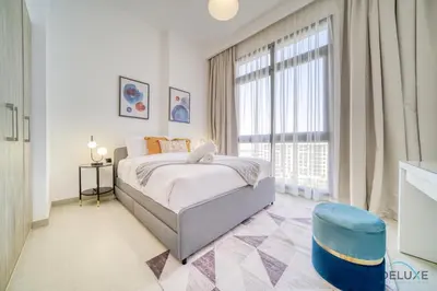 a bedroom with a bed and a large window at Sophisticated 1BR at Town Square Rawda Dubailand by Deluxe Holiday Homes in Dubai