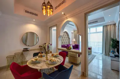 a dining room with a table and red chairs at Durrani Homes - Heaven on Earth in Dubai