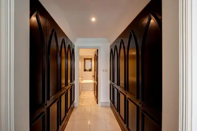 a hallway with black doors and a tile floor at Durrani Homes - Heaven on Earth in Dubai