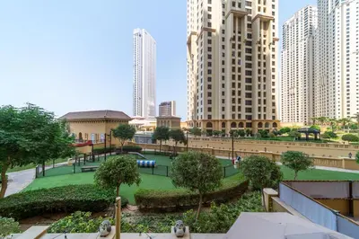 a park in the middle of a city with tall buildings at Elan Suites 5-Bedroom Beach Villa in Dubai