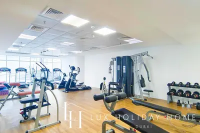 a gym with several tread machines in a room at LUX Marina View Prime Location Near Beach in Dubai
