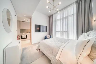 a white bedroom with a bed and a large window at Studio with City Views, Jumeirah Lake Towers - Mint Stay in Dubai