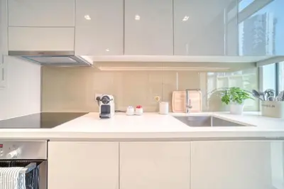 a kitchen with white cabinets and a sink at Studio with City Views, Jumeirah Lake Towers - Mint Stay in Dubai