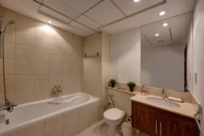 a bathroom with a tub and a toilet and a sink at Durrani Homes - Luxe Living with Burj Khalifa and Fountain View - third room without partition in Dubai