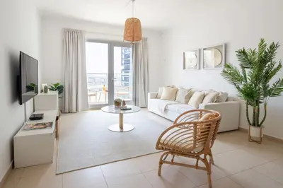 a living room with a white couch and a tv at Frank Porter - Grand Horizon in Dubai