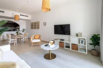 a living room with a white couch and a tv at Frank Porter - Grand Horizon in Dubai