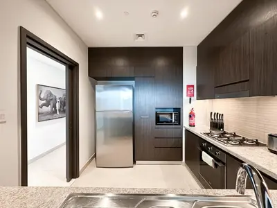 a kitchen with a stainless steel refrigerator and a sink at Stylish 2 Bedroom Dior-Inspired Apartment Connected to Dubai Mall in Dubai