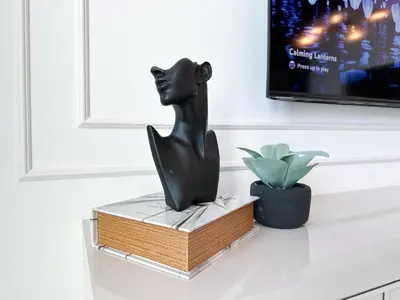 a black cat statue sitting on a shelf next to a plant at Stylish 2 Bedroom Dior-Inspired Apartment Connected to Dubai Mall in Dubai