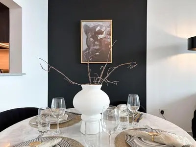 a table with a white vase and glasses on it at Stylish 2 Bedroom Dior-Inspired Apartment Connected to Dubai Mall in Dubai