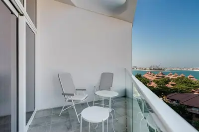 a balcony with two chairs and a view of the ocean at GlobalStay Azizi Mina Beachfront Apartments Palm Jumeirah in Dubai